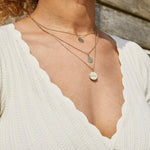 model wearing solid gold necklaces layered including the Organic Coin engraved pendant 9k Gold