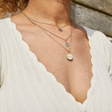 model wearing solid gold necklaces layered including the Organic Coin engraved pendant 9k Gold