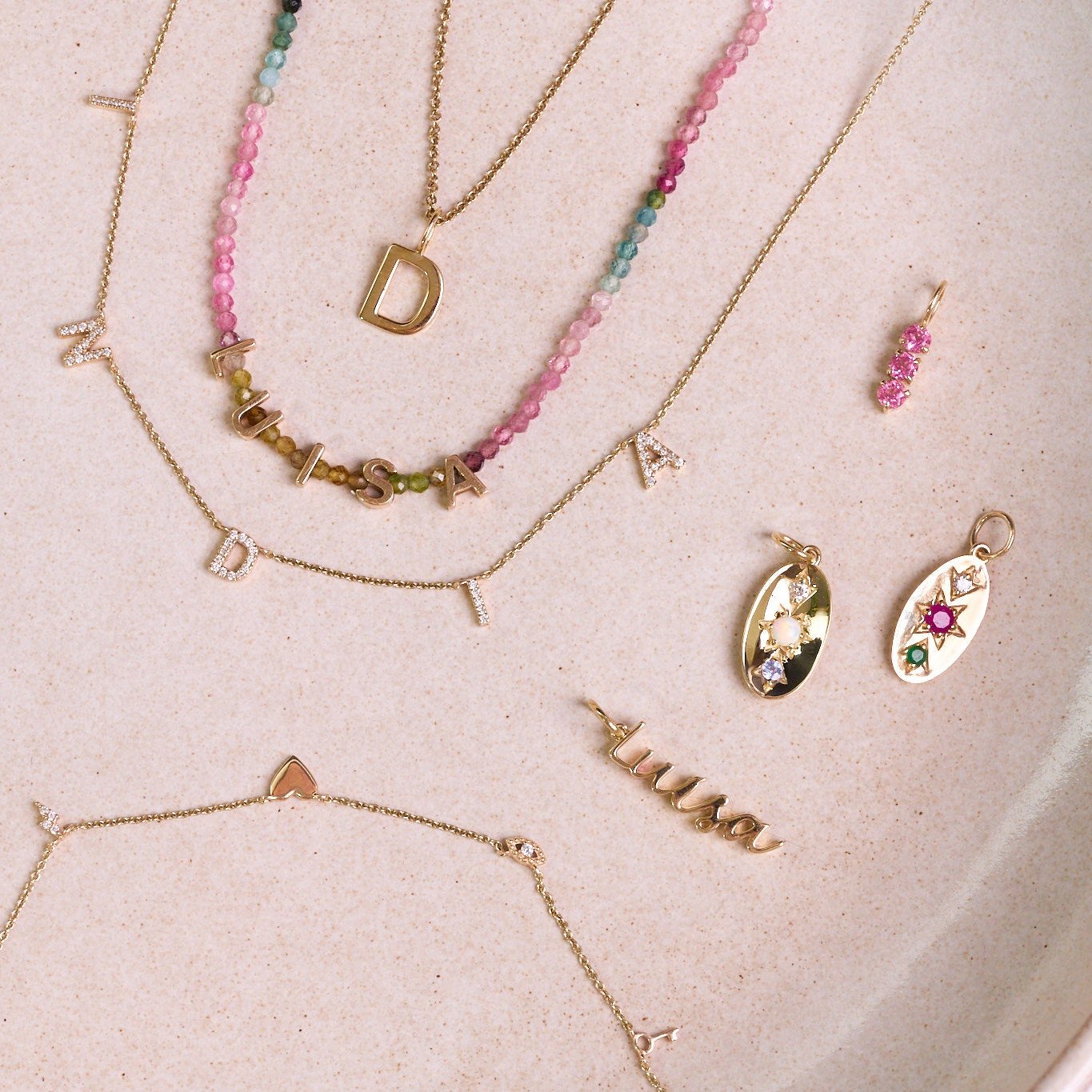 solid gold jewellery on hard surface including the Personalised Domed Pendant 9k Gold