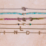 solid metal bracelets on hard surface including the Birthstone Trio Bracelet 9k Gold