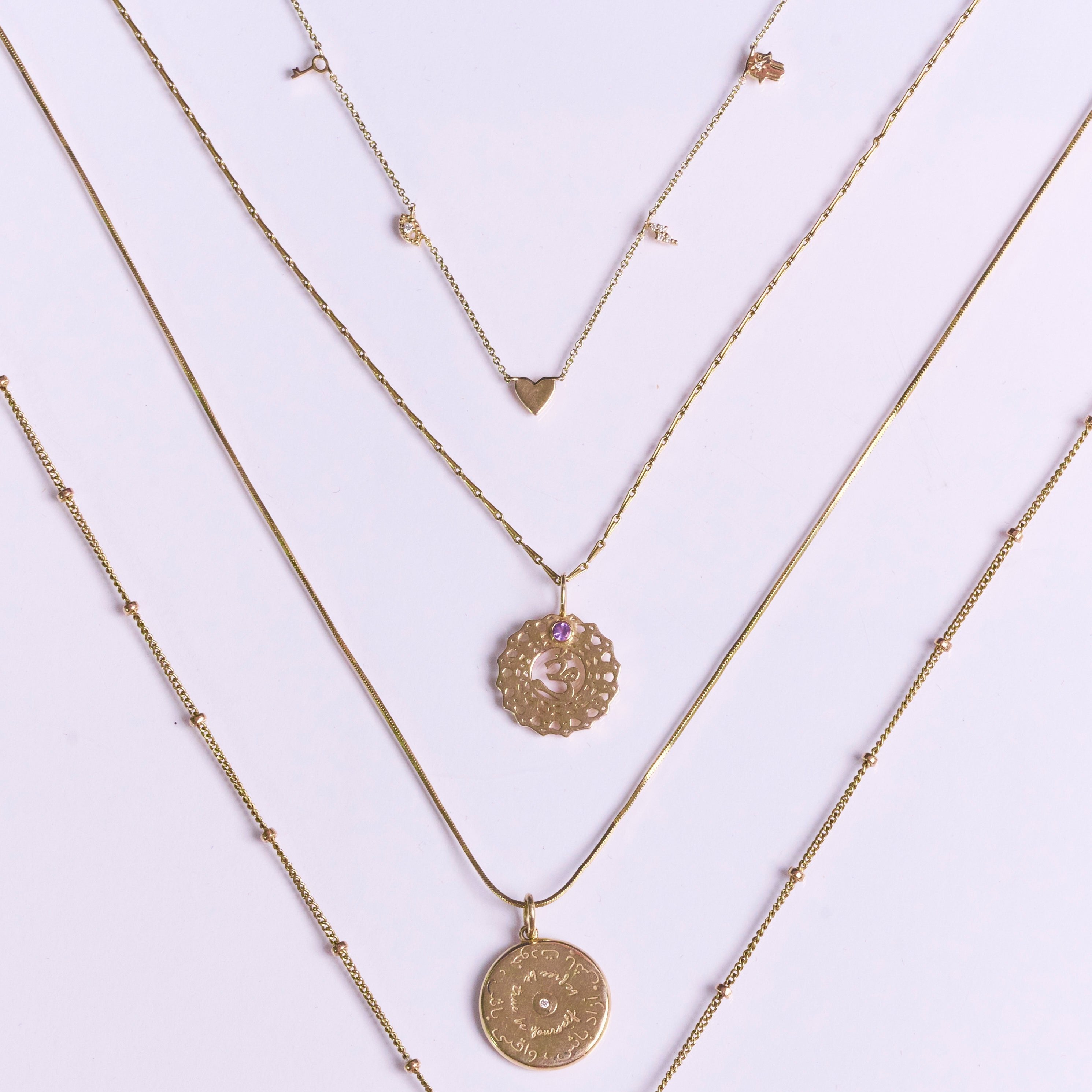 Personalised Initial Necklace 9k Gold  displayed along with other solid gold necklaces