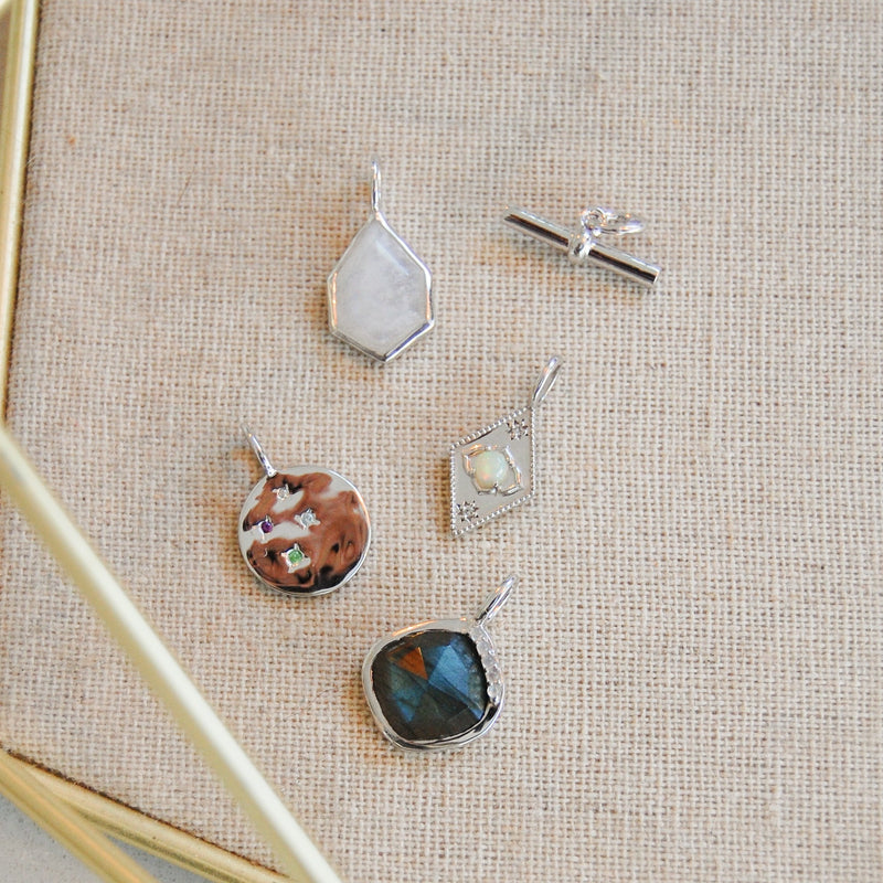 silver pendants in jewellery tray including the Multi Semi-Precious Organic Coin Pendant Sterling Silver