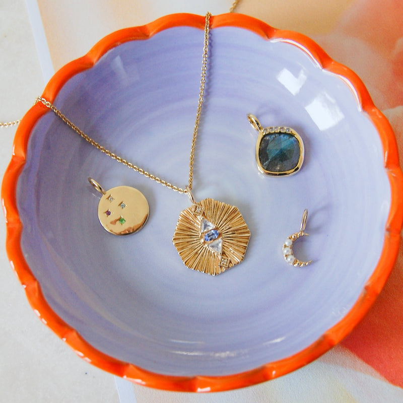 gold pendants in ceramic bowl including the Multi Semi-Precious Organic Coin Pendant 9k Gold
