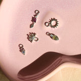 silver charms with stone on pink plate