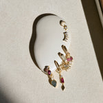 gold charms on white ear in shadow