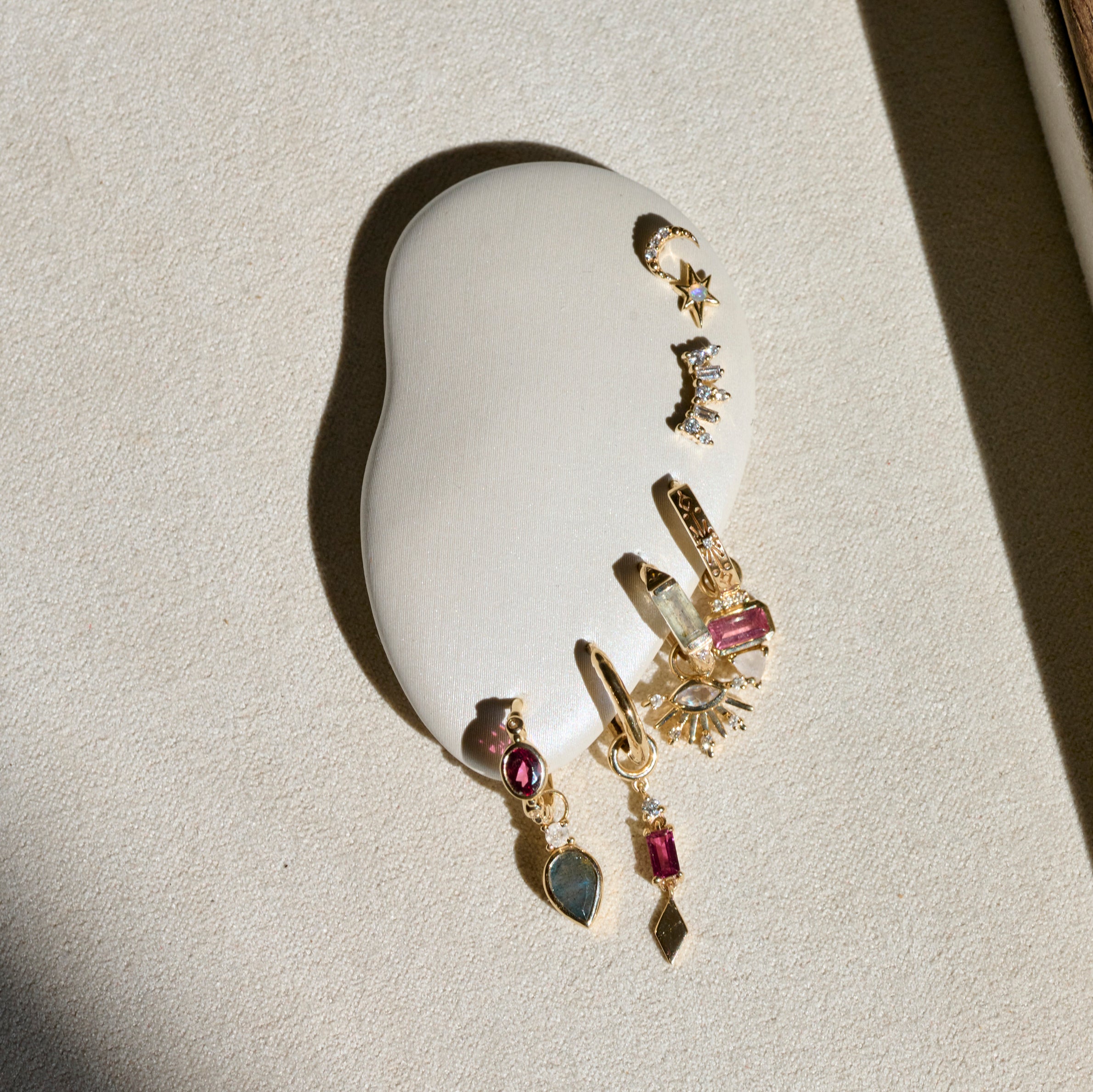 gold charms on white ear in shadow