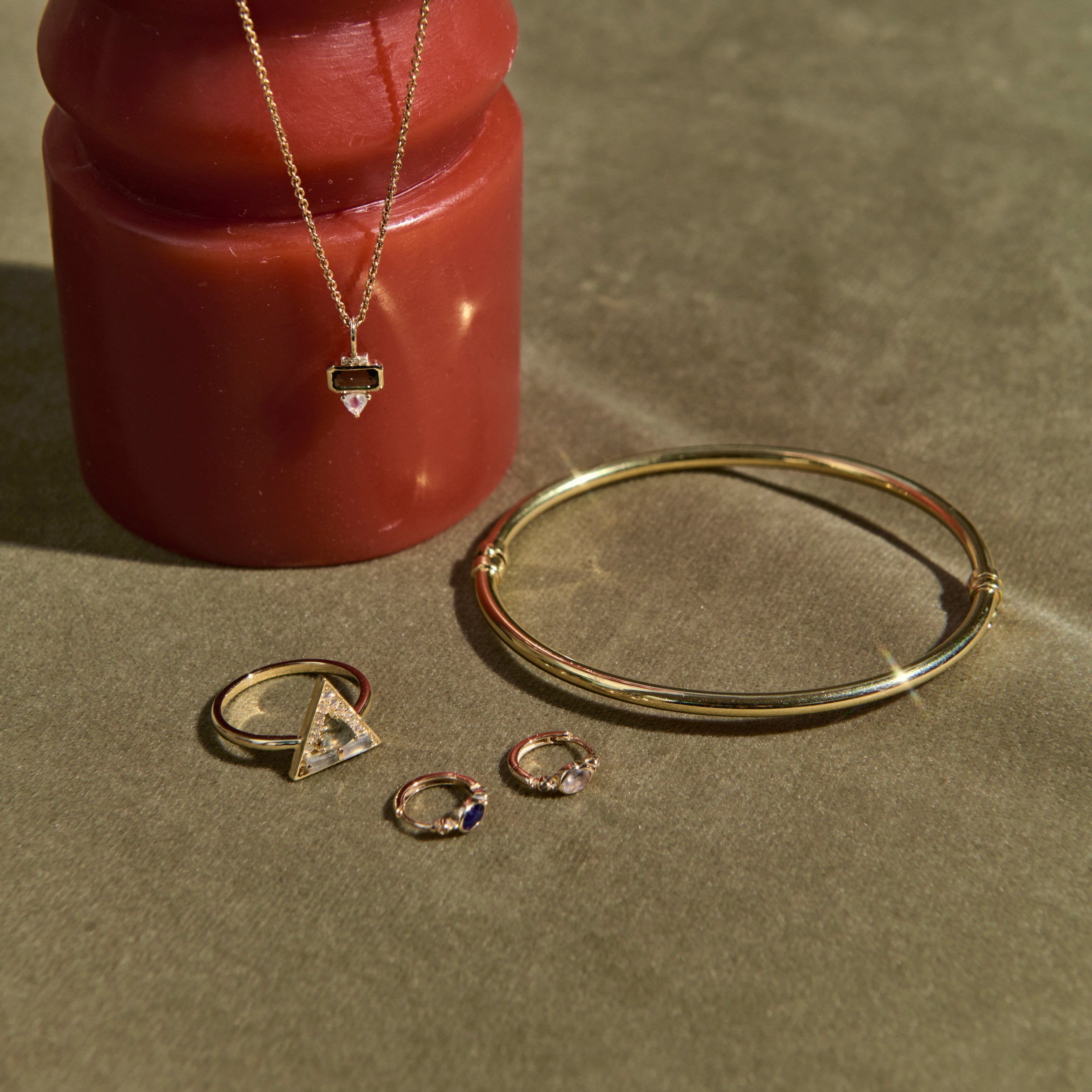solid gold jewellery on green background and red object