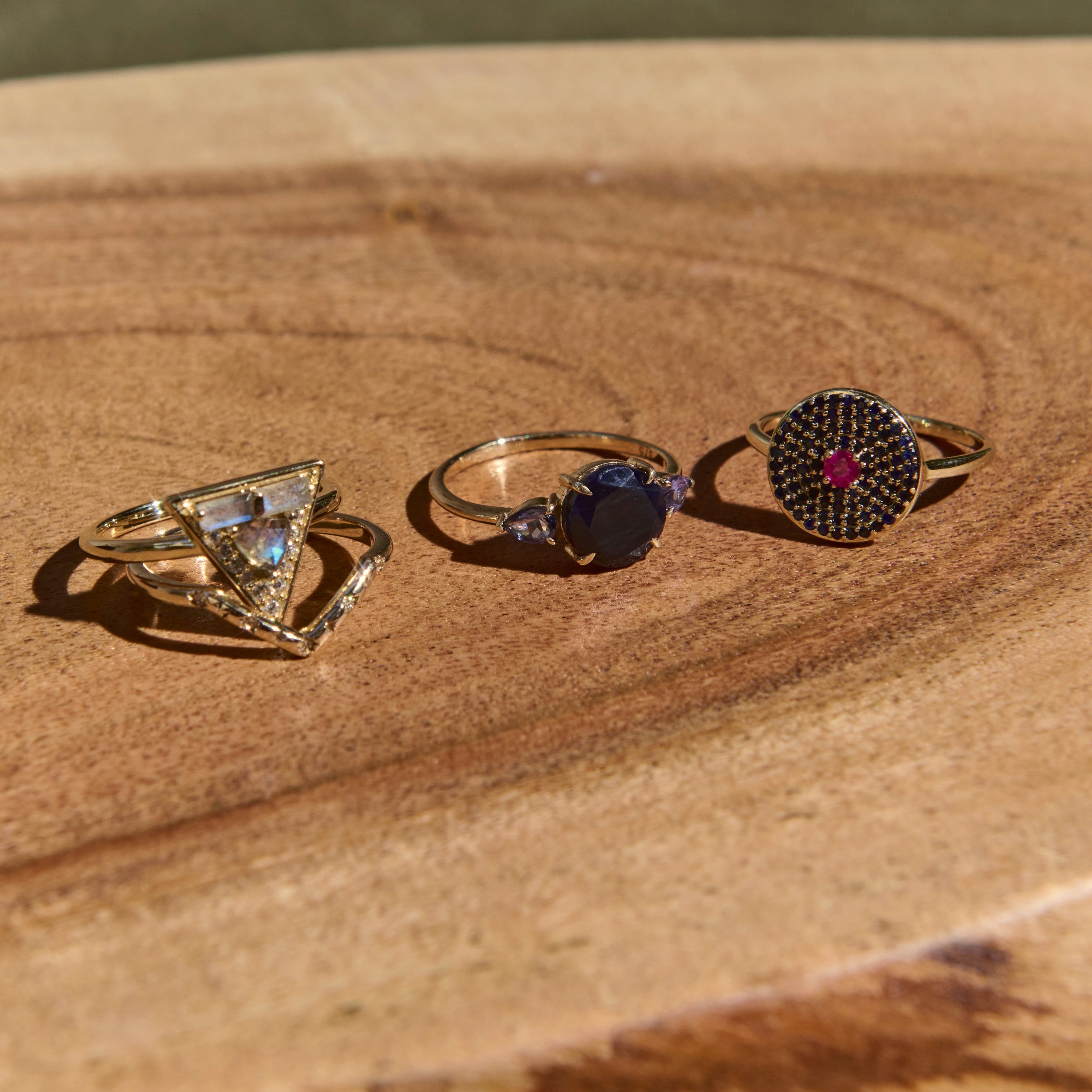 Three rings with different designs on a wooden surface