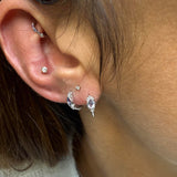 close up of two silver earrings 