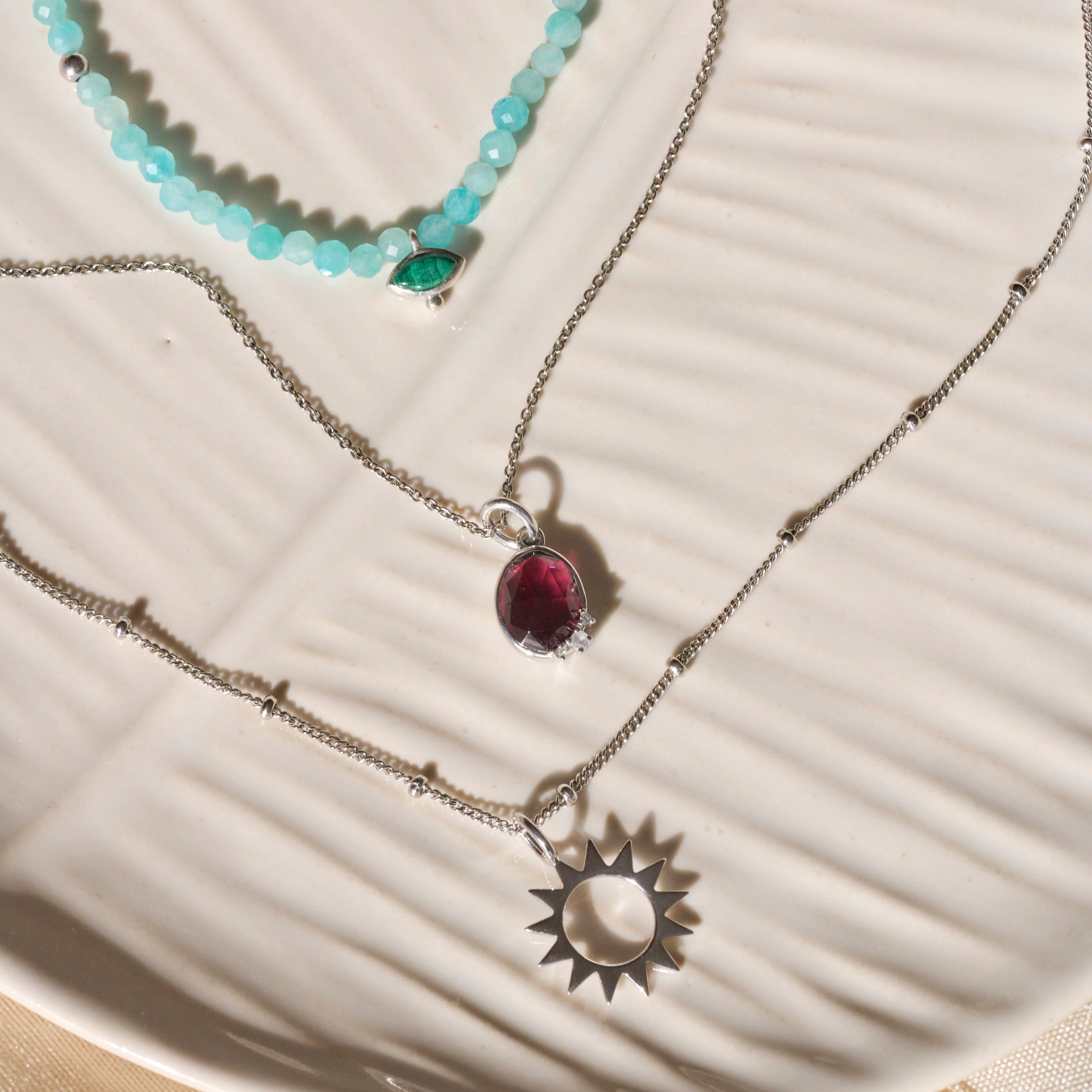 sterling silver necklaces on off white dish