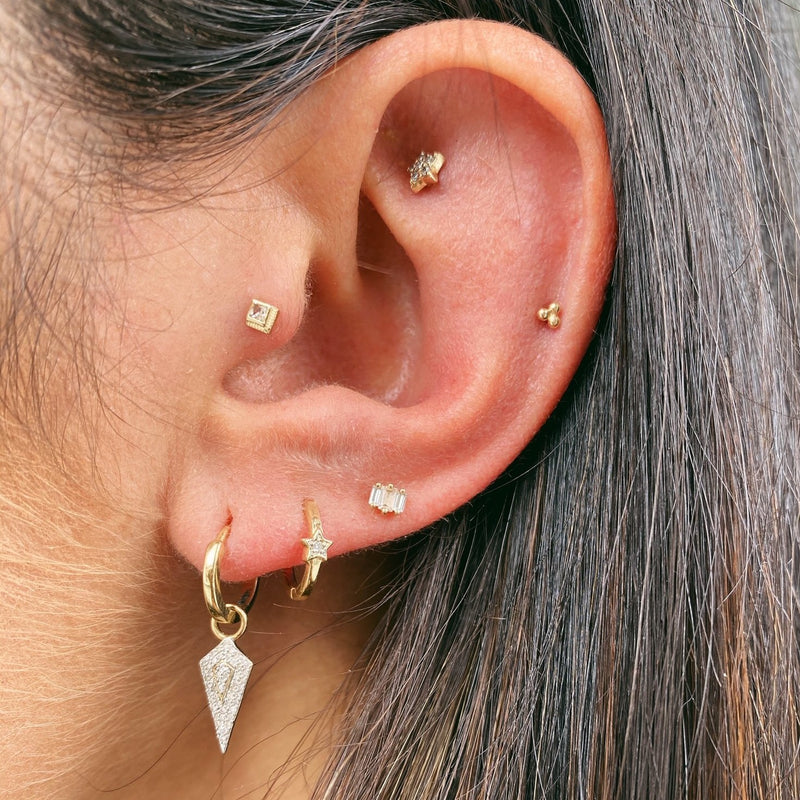 model wearing gold ear stack with diamond rhombus earring charm in 9k gold