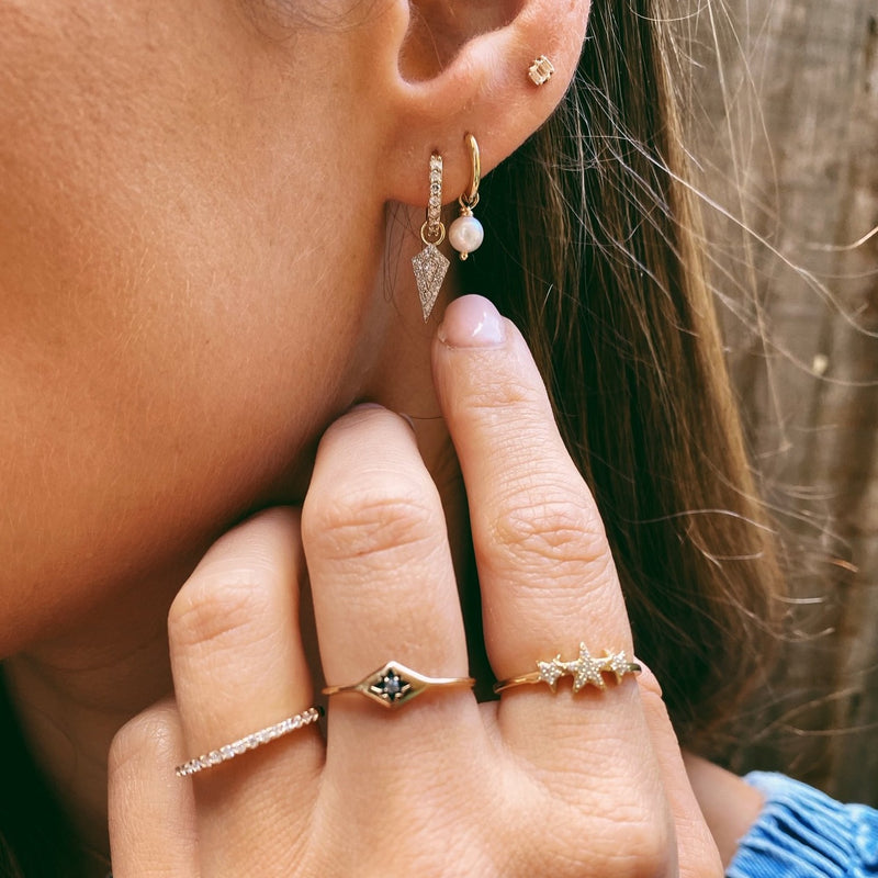 model wearing various earrings including diamond rhombus earring charm in 9k gold