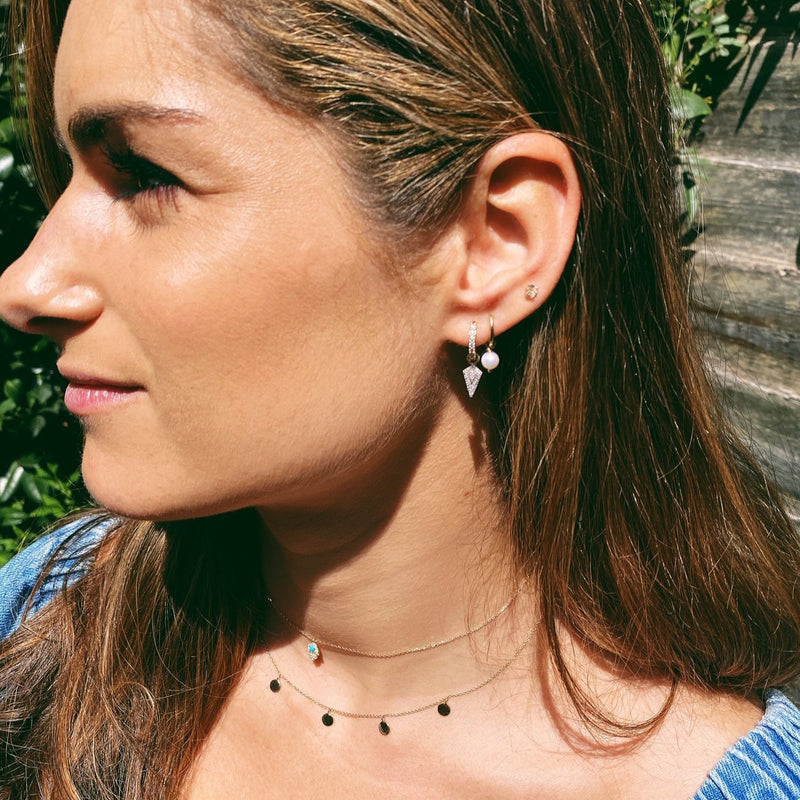 image of model wearing ear stack featuring diamond rhombus earring charm in 9k gold