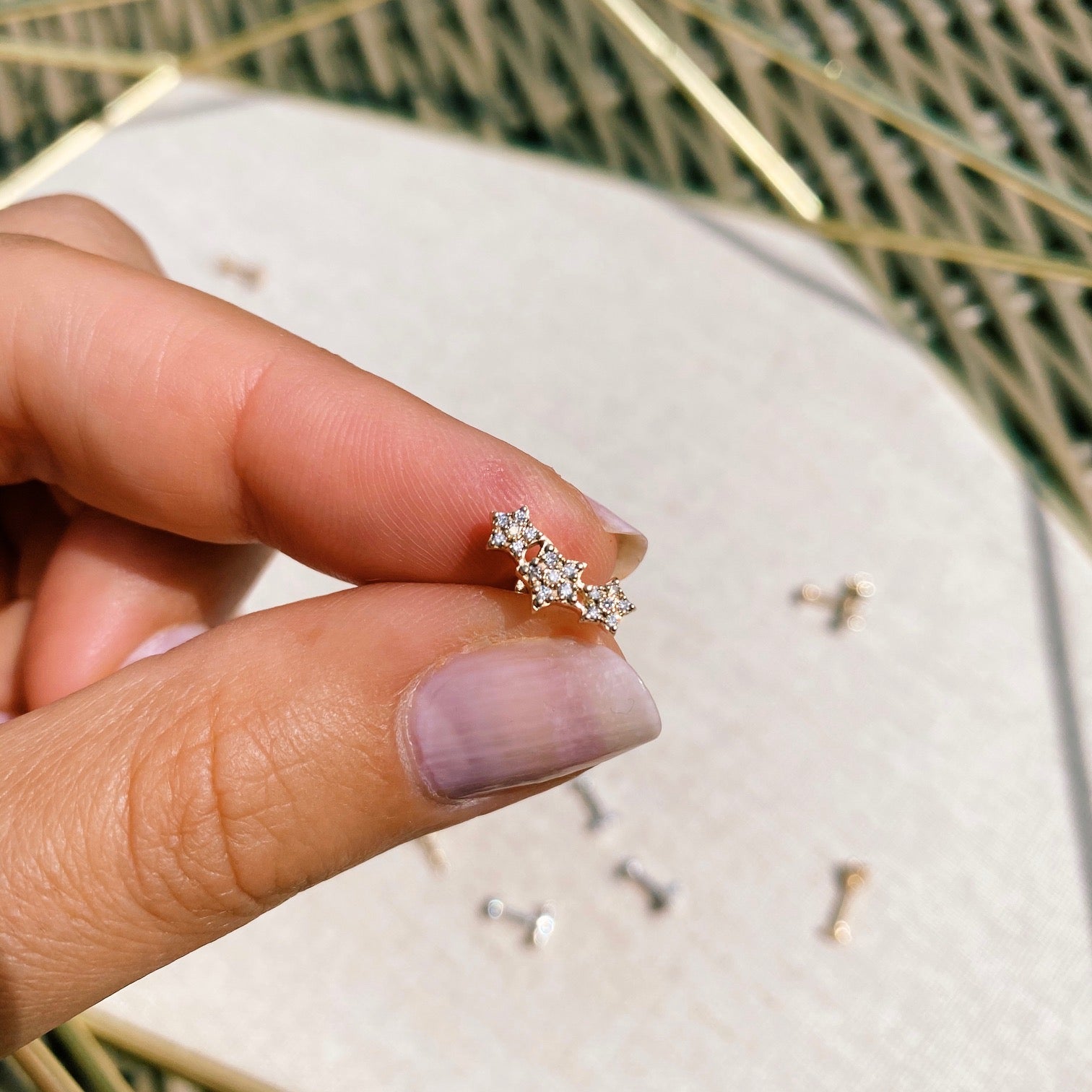 Close up of diamond star cluster flat back earring gold in hand