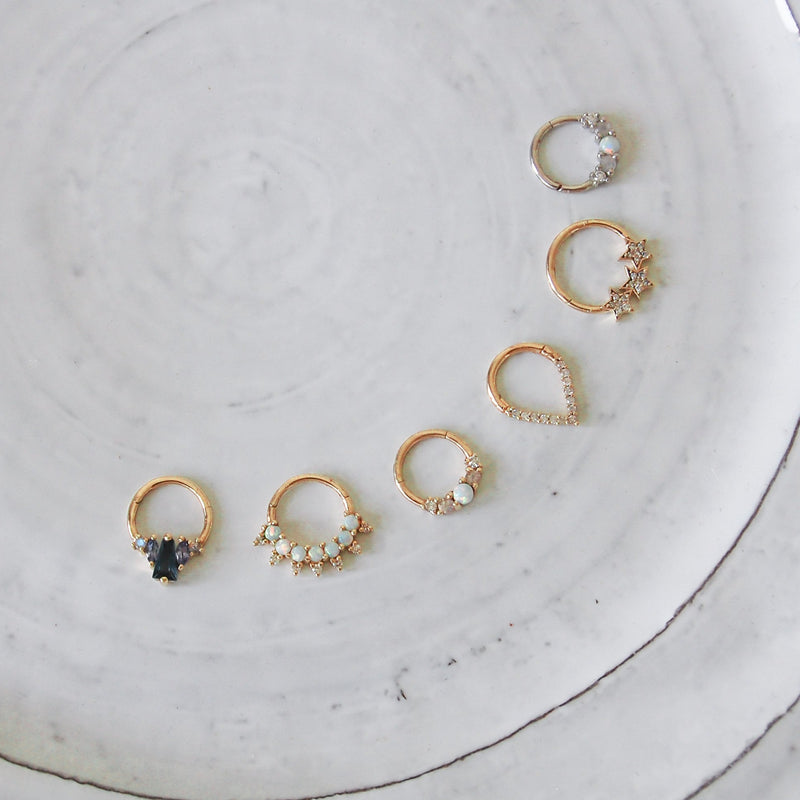 Collection of 6 individual daith earrings featuring London blue topaz, with tanzanite, moonstone & 9 karat gold.