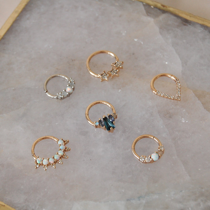 A collection of 6 daith earrings including one london blue topaz 9 karat gold hoop with tanzanite & moonstone