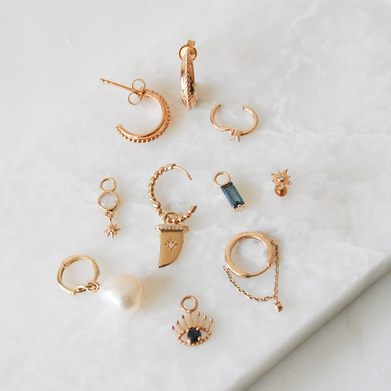 range of different earrings and charms including baroque pearl in 9k gold