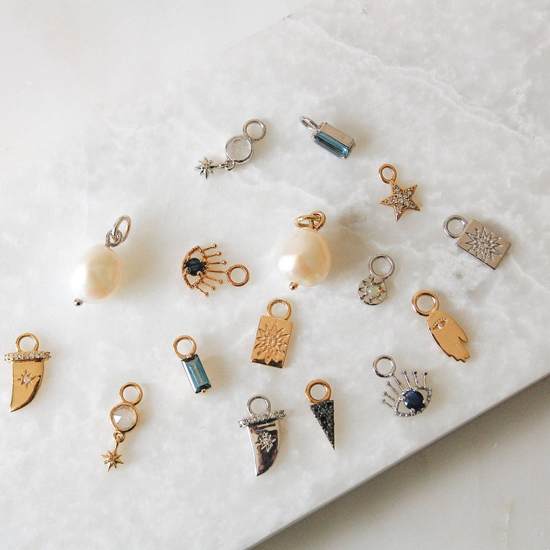 variety of different earring charms including 9k gold hand of fatima