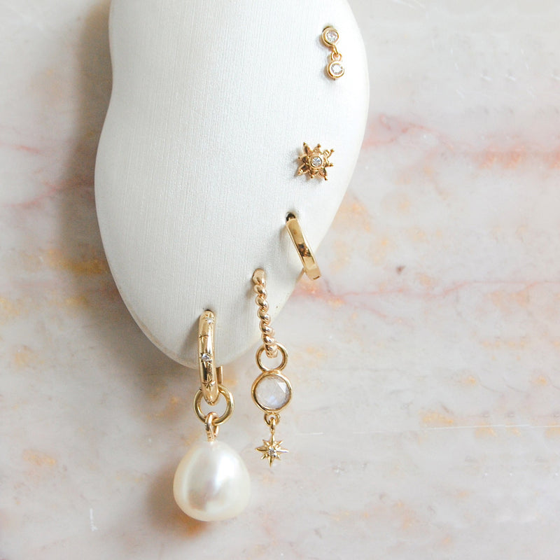 image of different earrings in stand including baroque pearl earring charm