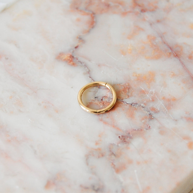 Seamless earring hoop made with 9 karat gold displayed on a pink marble background