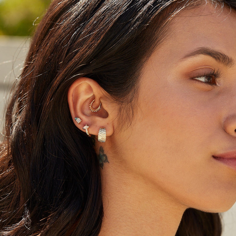 model wearing ear stack including beaded hoop daith earring in 9k gold