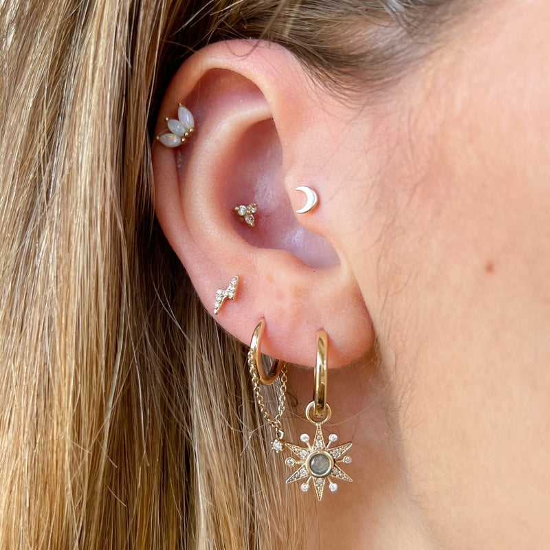 model wearing various earrings including diamond and labradorite 9k gold star earring charm