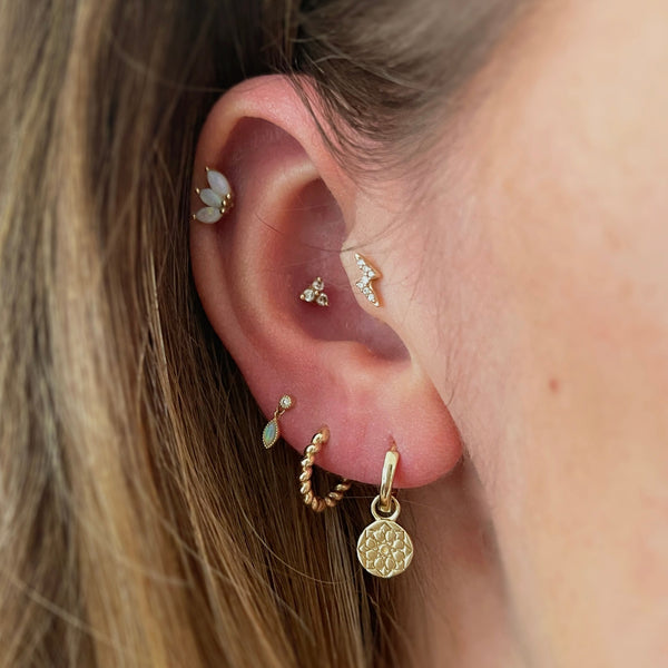 EAR WITH GOLD EARRINGS AND PIERCINGS