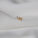 close up of the Snake Flat Back Earring 14k Gold on fabric
