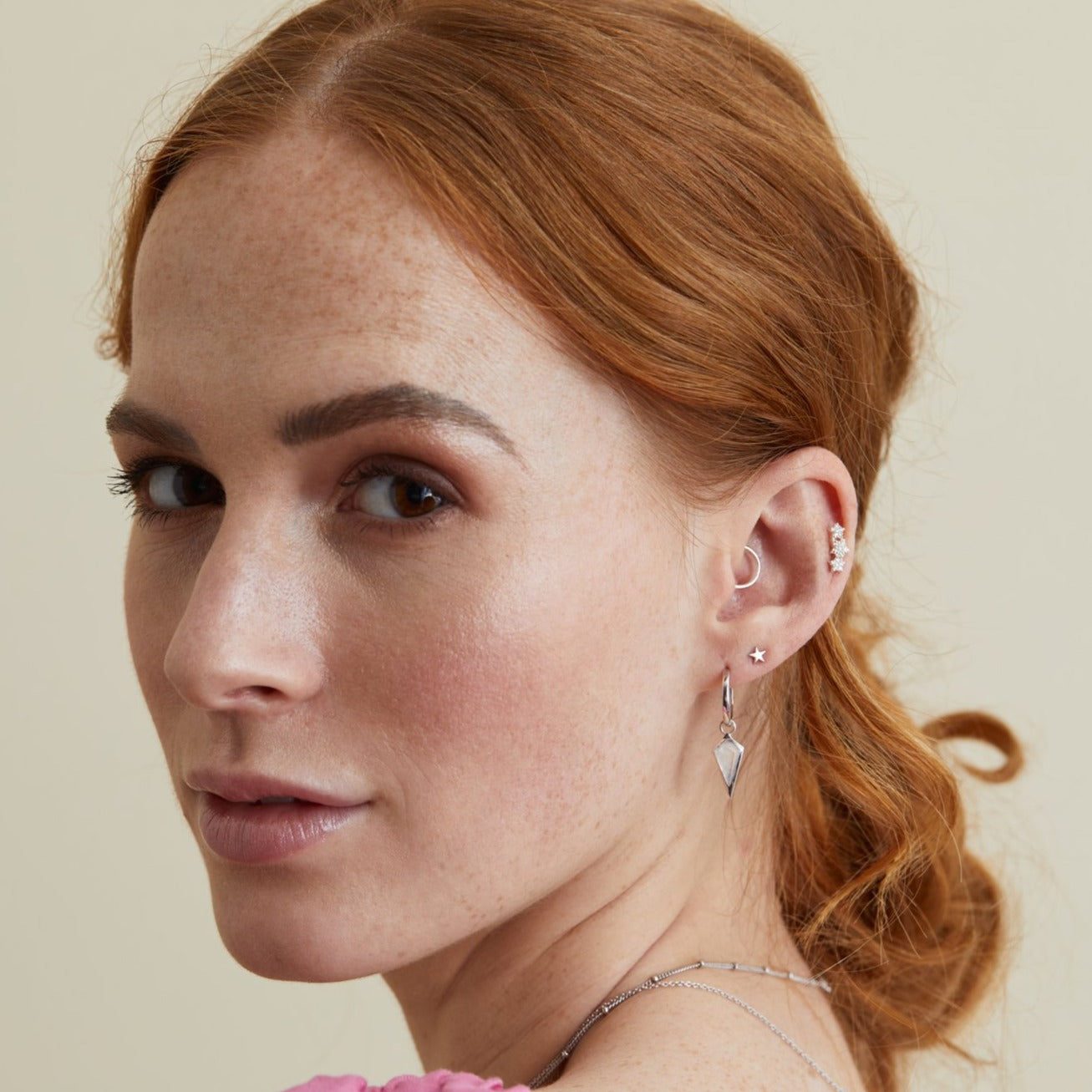 model wearing ear stack including 9k gold daith hoop earring