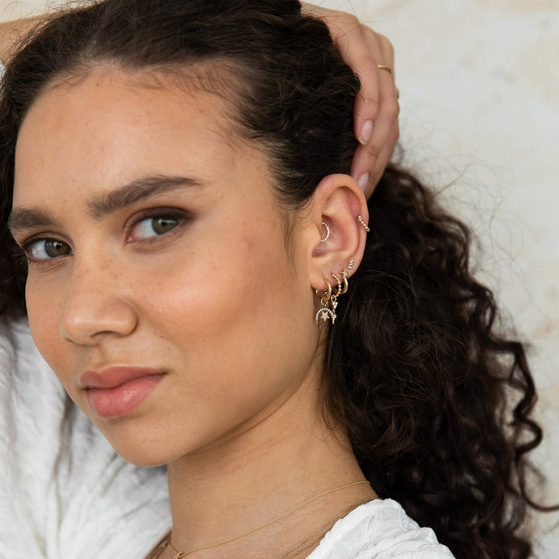model wearing ear stack including diamond pave daith hoop in 9k gold