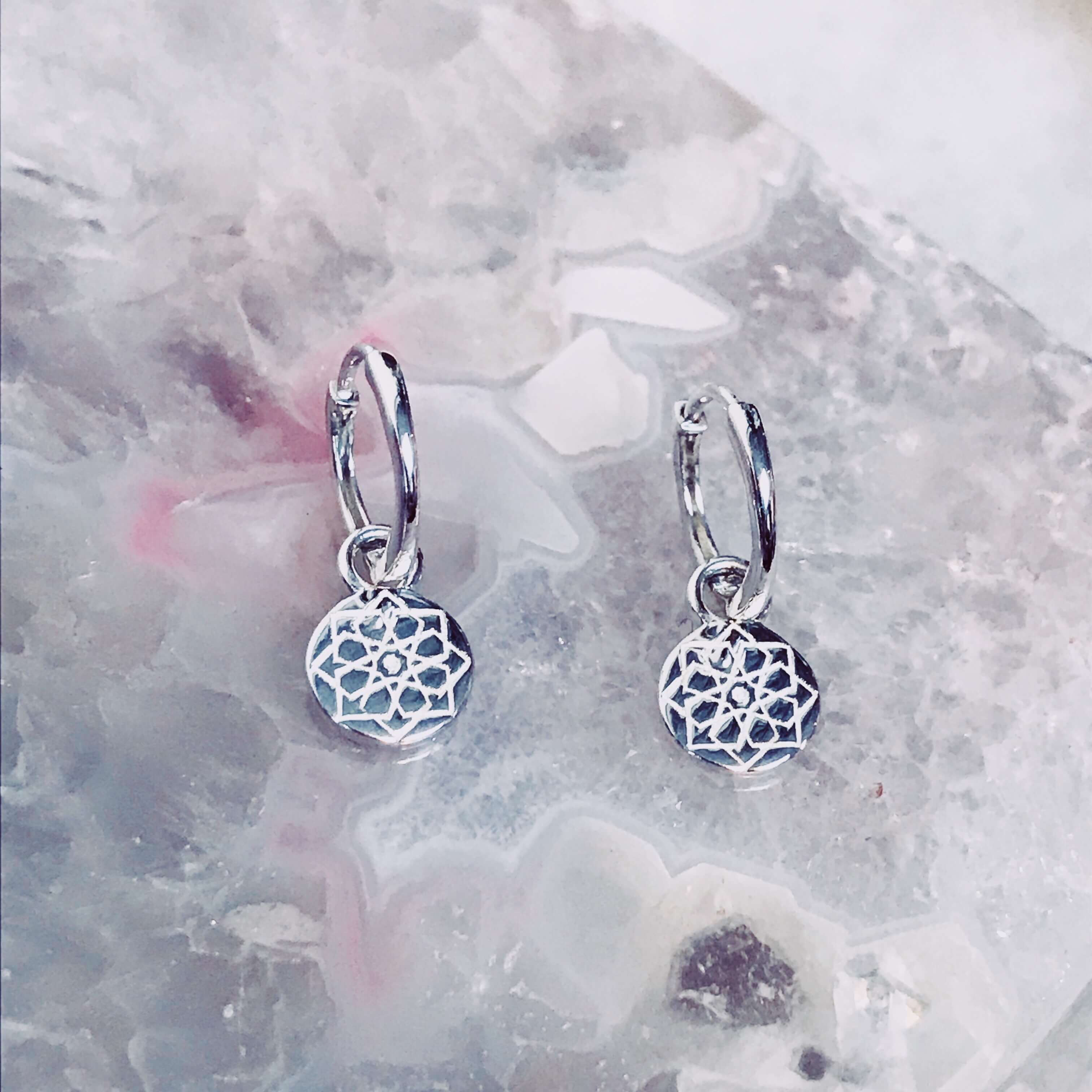 Zohreh Coin Charm Hoop Earrings Sterling Silver on hard surface