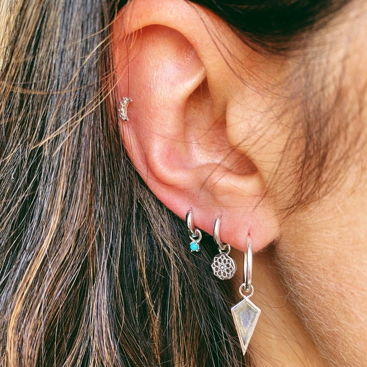 close up of ear stack sterling silver earrings including the Zohreh Coin Earring Charm Sterling Silver