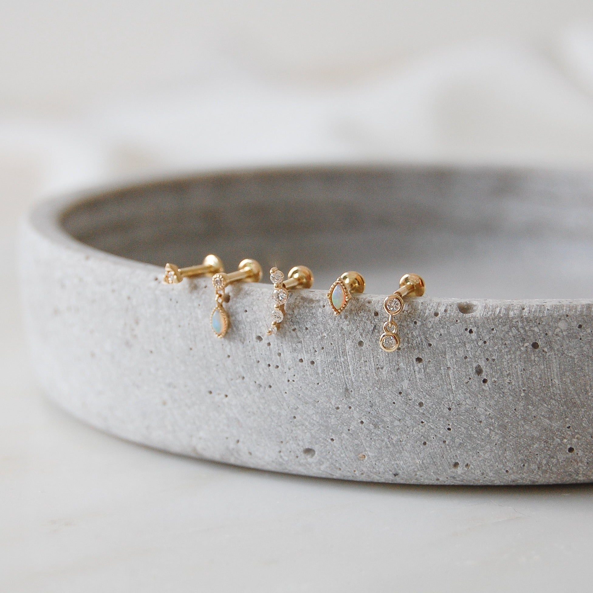 An array of flat back earrings on stone dish